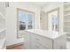 Bright walk-in closet with custom shelving and drawers; window provides ample natural light at 10756 Dartmoor Way, Zionsville, IN 46077