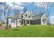 Well-manicured two-story home with gray siding, gray shingles, and a lush lawn at 10756 Dartmoor Way, Zionsville, IN 46077