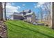 Beautiful home featuring a large manicured lawn, gray siding, stone accents, and a charming outdoor firepit area at 10756 Dartmoor Way, Zionsville, IN 46077