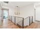 Bright hallway features hardwood floors, modern railing, and elegant light fixture at 10756 Dartmoor Way, Zionsville, IN 46077