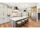 Spacious kitchen featuring a large island with seating, custom cabinets, and modern appliances at 10756 Dartmoor Way, Zionsville, IN 46077