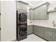 Bright laundry room with modern washer and dryer, updated cabinets, and light countertops at 10756 Dartmoor Way, Zionsville, IN 46077