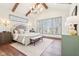 This spacious main bedroom has wood beams, a decorative light fixture, and a decorative bed at 10756 Dartmoor Way, Zionsville, IN 46077