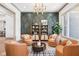 Inviting sitting room with accent wall, chandelier lighting, and comfortable leather chairs at 10756 Dartmoor Way, Zionsville, IN 46077