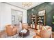 Sitting room featuring a patterned wall, chandelier, built-in shelves, and leather chairs at 10756 Dartmoor Way, Zionsville, IN 46077