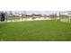 Spacious backyard with lush green grass, a pond, and play equipment at 1142 Cobra Dr, Franklin, IN 46131