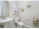 Well-lit powder room with a pedestal sink and decor, offering a stylish space for guests at 1142 Cobra Dr, Franklin, IN 46131