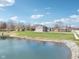 Aerial view of a landscaped property featuring a pond, home exterior, shed, and charming neighborhood at 12121 N Berling Dr, Mooresville, IN 46158