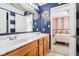 Bathroom featuring dual sinks, wood cabinets, nautical decor, and a view into an adjacent bedroom at 12121 N Berling Dr, Mooresville, IN 46158