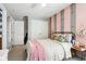 Cozy bedroom with a rustic pink and wood accent wall, a ceiling fan, carpet, and a large closet at 12121 N Berling Dr, Mooresville, IN 46158