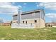View of the home's exterior featuring a brick foundation and gray siding under a sunny blue sky at 12121 N Berling Dr, Mooresville, IN 46158