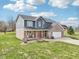 Two-story home featuring a brick and siding exterior, a front porch, and a well-manicured lawn at 12121 N Berling Dr, Mooresville, IN 46158