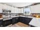 A modern kitchen features white cabinets and black appliances with recessed lighting at 12121 N Berling Dr, Mooresville, IN 46158
