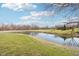 A serene pond surrounded by lush green grass and mature trees adds to the property's charm at 12121 N Berling Dr, Mooresville, IN 46158