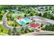 Aerial view showcasing the community pool, playground, and clubhouse near lush landscaping at 12307 Pebblepointe Pass, Carmel, IN 46033