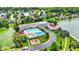 A picturesque aerial view of the community clubhouse, pool, and well-manicured landscaping near the lake at 12307 Pebblepointe Pass, Carmel, IN 46033