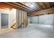 Unfinished basement with concrete floor, exposed wooden beams, and access to stairs at 12307 Pebblepointe Pass, Carmel, IN 46033