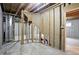 Unfinished basement with concrete floor, exposed wooden beams, and access to another room at 12307 Pebblepointe Pass, Carmel, IN 46033