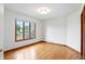 Bright bedroom featuring gleaming hardwood floors, a large window with views, and white walls at 12307 Pebblepointe Pass, Carmel, IN 46033