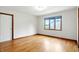 Inviting bedroom with hardwood floors, a window offering natural light, and a paneled door at 12307 Pebblepointe Pass, Carmel, IN 46033