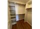 Walk in closet with built in shelves, wooden trim, and hardwood floors at 12307 Pebblepointe Pass, Carmel, IN 46033