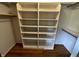 Walk in closet with a built in shelving system and wooden floors at 12307 Pebblepointe Pass, Carmel, IN 46033