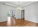 Light-filled dining room with hardwood floors, modern chandelier, and classic wainscoting at 12307 Pebblepointe Pass, Carmel, IN 46033