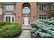 Elegant brick home entrance with manicured shrubs and a pristine white front door with large arched window at 12307 Pebblepointe Pass, Carmel, IN 46033