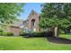 Traditional brick home with mature trees and landscaping, offering a serene and inviting curb appeal at 12307 Pebblepointe Pass, Carmel, IN 46033