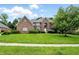 Charming brick home with a well-maintained lawn and lush green shrubbery under a bright blue sky at 12307 Pebblepointe Pass, Carmel, IN 46033
