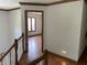 Hallway with wood trim and hardwood floors leads to bedroom with window at 12307 Pebblepointe Pass, Carmel, IN 46033