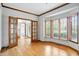 Comfortable living room with hardwood floors, large bay window, and wood-trimmed doorway at 12307 Pebblepointe Pass, Carmel, IN 46033