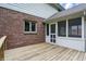 Wooden patio featuring brick wall and a screened door leading to outside, with lush greenery beyond at 12307 Pebblepointe Pass, Carmel, IN 46033