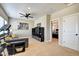 Bonus room with exercise equipment, gray couch, TV and adjacent bedroom at 1591 W 151St St, Westfield, IN 46074
