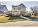 Inviting two-story home featuring a classic front porch, red brick accents and green siding at 1591 W 151St St, Westfield, IN 46074