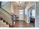 Bright foyer featuring hardwood floors, a staircase with wooden railing and a glass pendant light fixture at 1591 W 151St St, Westfield, IN 46074