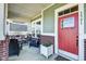 Inviting front porch featuring a vibrant red door, potted flowers, and comfortable seating arrangements at 1591 W 151St St, Westfield, IN 46074