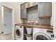This laundry room has gray cabinets, decorative tile backsplash, wooden countertop, and washer/dryer at 1591 W 151St St, Westfield, IN 46074