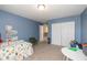 A colorful bedroom with vibrant blue walls, soft carpeting and ample space for play and relaxation at 1773 Winchester Blvd, Avon, IN 46123