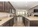 Open kitchen with granite countertops, stainless steel appliances, and dark cabinetry that flows into a living area at 1773 Winchester Blvd, Avon, IN 46123