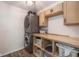 Efficient laundry room with stacked washer and dryer, wooden countertop, and ample storage space at 1773 Winchester Blvd, Avon, IN 46123