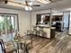 Inviting dining area with a glass table set next to a sunroom and kitchen, featuring wood-look flooring at 2408 E Stafford Pl, Martinsville, IN 46151