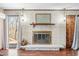 Cozy fireplace with brick surround, mantel, and large window bringing in natural light at 2408 E Stafford Pl, Martinsville, IN 46151