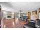 Open living room with fireplace, hardwood floors, and comfortable black leather seating at 2408 E Stafford Pl, Martinsville, IN 46151