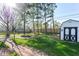 Spacious backyard featuring a fire pit, wooden swing set, and storage shed at 245 Suncrest Dr, Greenwood, IN 46143