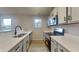 Modern kitchen with stainless steel appliances, white cabinetry, quartz countertops, and wood-look flooring at 2617 N Temple Ave, Indianapolis, IN 46218