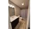 Bathroom with a shower and tub combo and modern sink with decorative lighting and dark wood vanity at 298 Rocky Rd, Greenfield, IN 46140
