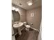 Charming half bathroom with pedestal sink, decorative oval mirror and stylish flooring at 298 Rocky Rd, Greenfield, IN 46140