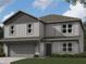 Charming two-story home featuring vertical siding, a gray roof, manicured lawn, and an attached two-car garage at 3296 W Longbranch Dr, Monrovia, IN 46157