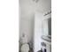 A bright white powder room featuring a pedestal sink and toilet under slanted ceiling at 3432 Shepperton Blvd, Indianapolis, IN 46228